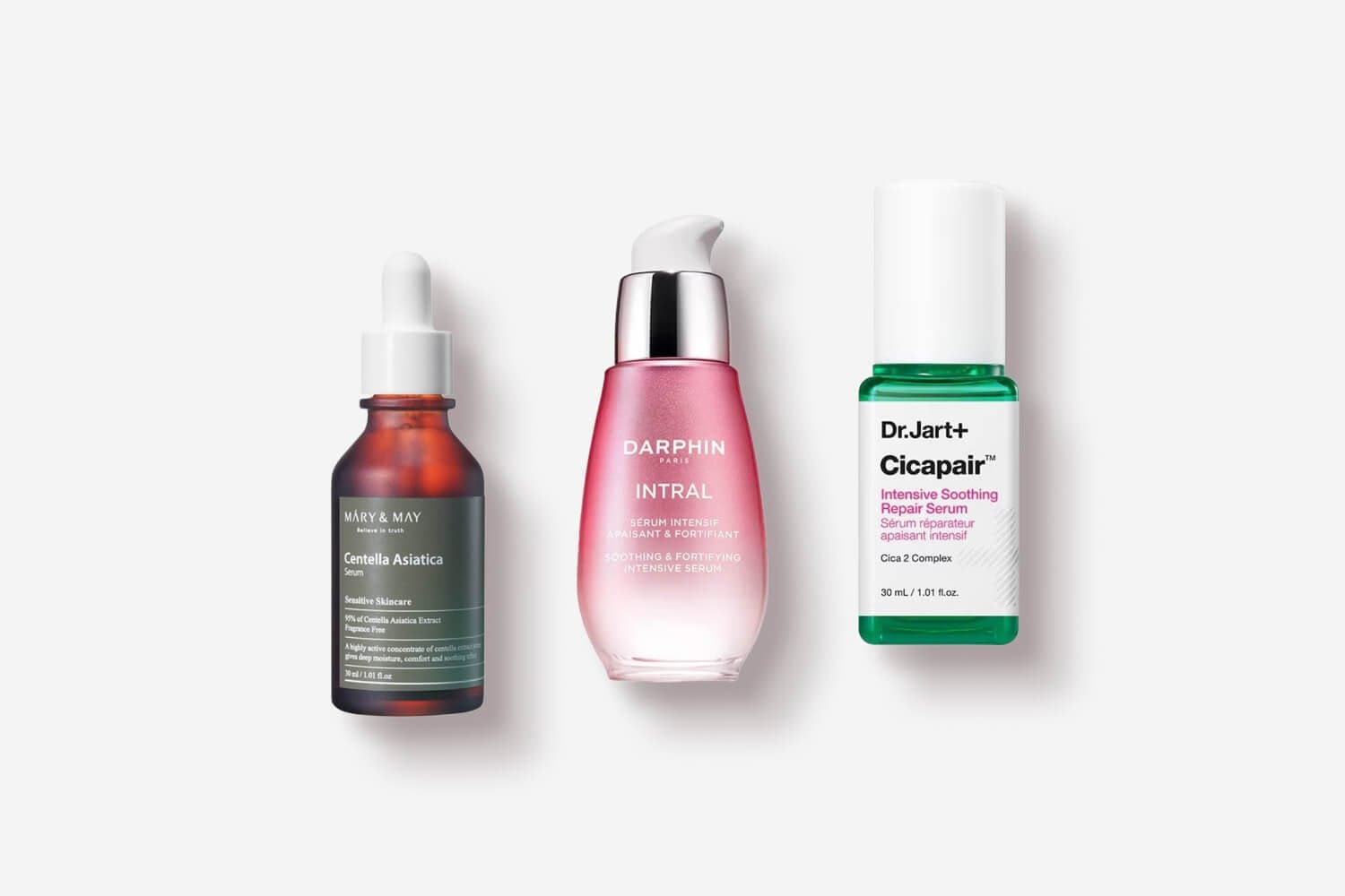 Mary & May Centella Asiatica Serum, Darphin Intral Soothing & Fortifying Intensive Serum and Dr.Jart+ Cicapair Intensive Soothing Repair Serum on grey. Mary & May Centella Asiatica Serum, Darphin Intral Soothing & Fortifying Intensive Serum and Dr.Jart+ Cicapair Intensive Soothing Repair Serum on grey.