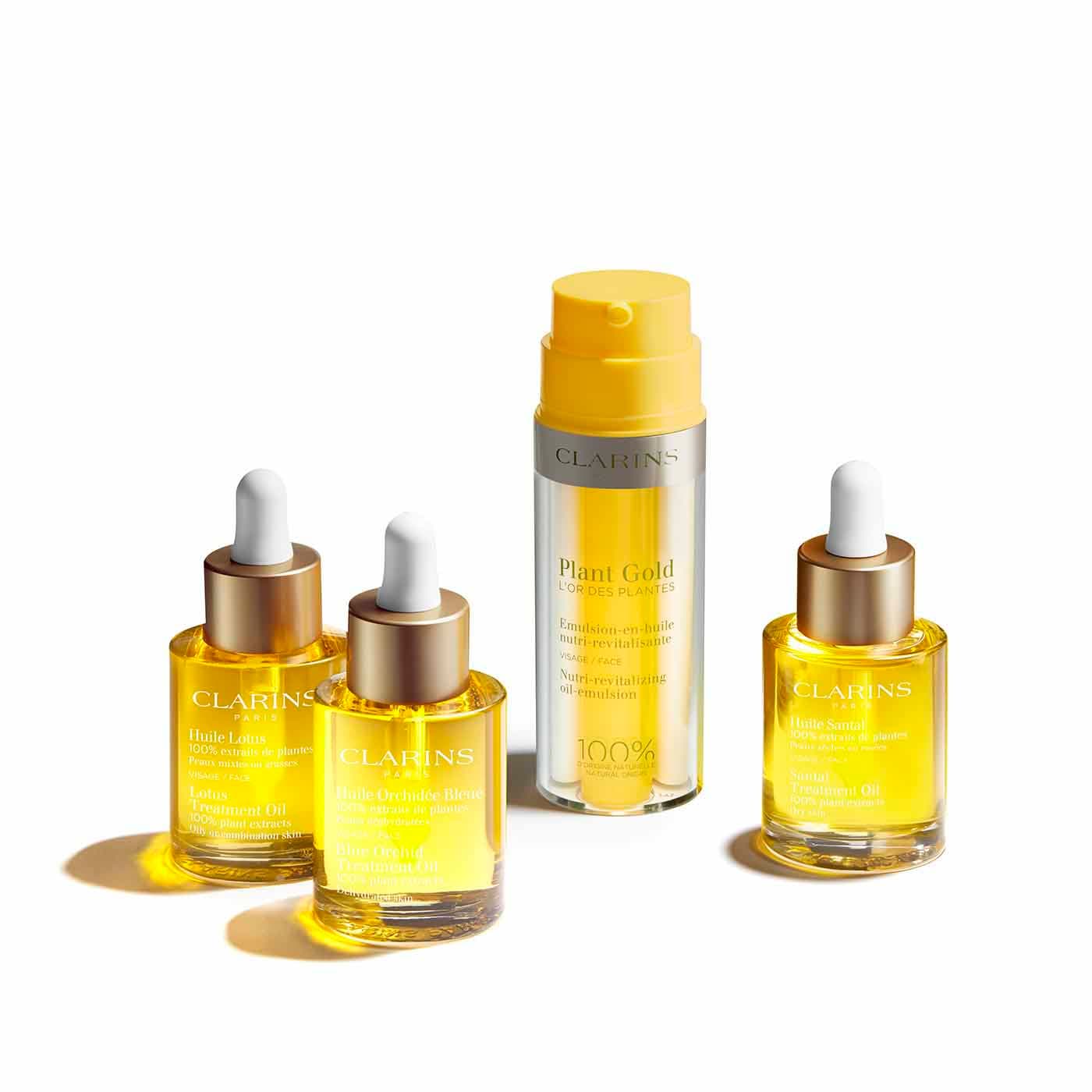 Clarins Lotus, Blue Orchid and Santal Treatment Oil dropper bottles beside the Plant Gold Nutri-Revitalizing Oil-Emulsion pump. Clarins Lotus, Blue Orchid and Santal Treatment Oil dropper bottles beside the Plant Gold Nutri-Revitalizing Oil-Emulsion pump.