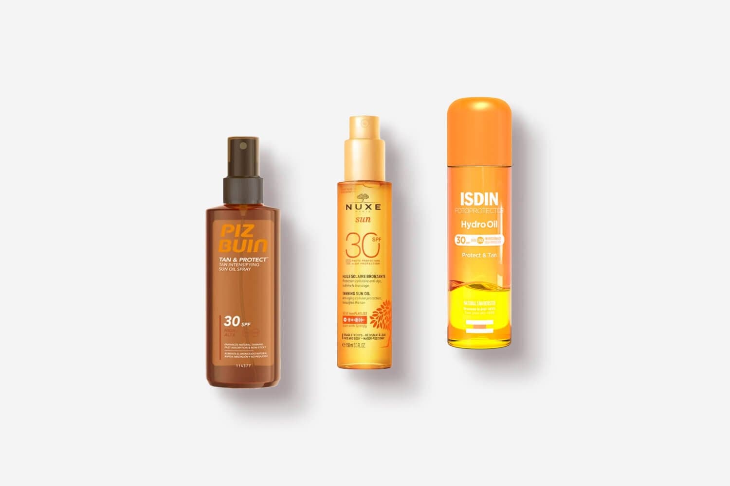 Piz Buin Tan & Protect Sun Oil Spray SPF 30, Nuxe Sun Tanning Sun Oil SPF 30 and ISDIN Fotoprotector Hydro Oil SPF 30 on grey Piz Buin Tan & Protect Sun Oil Spray SPF 30, Nuxe Sun Tanning Sun Oil SPF 30 and ISDIN Fotoprotector Hydro Oil SPF 30 on grey