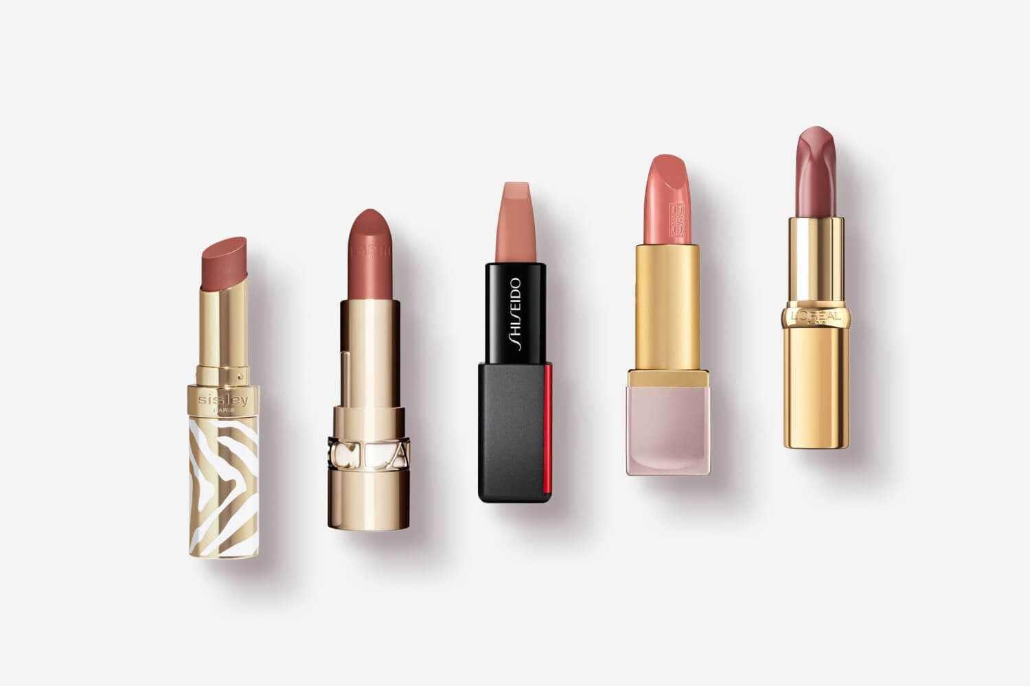 Five open nude lipsticks in a row on grey: Sisley Paris, Dior, Shiseido ModernMatte, Givenchy and L'Oréal Paris.