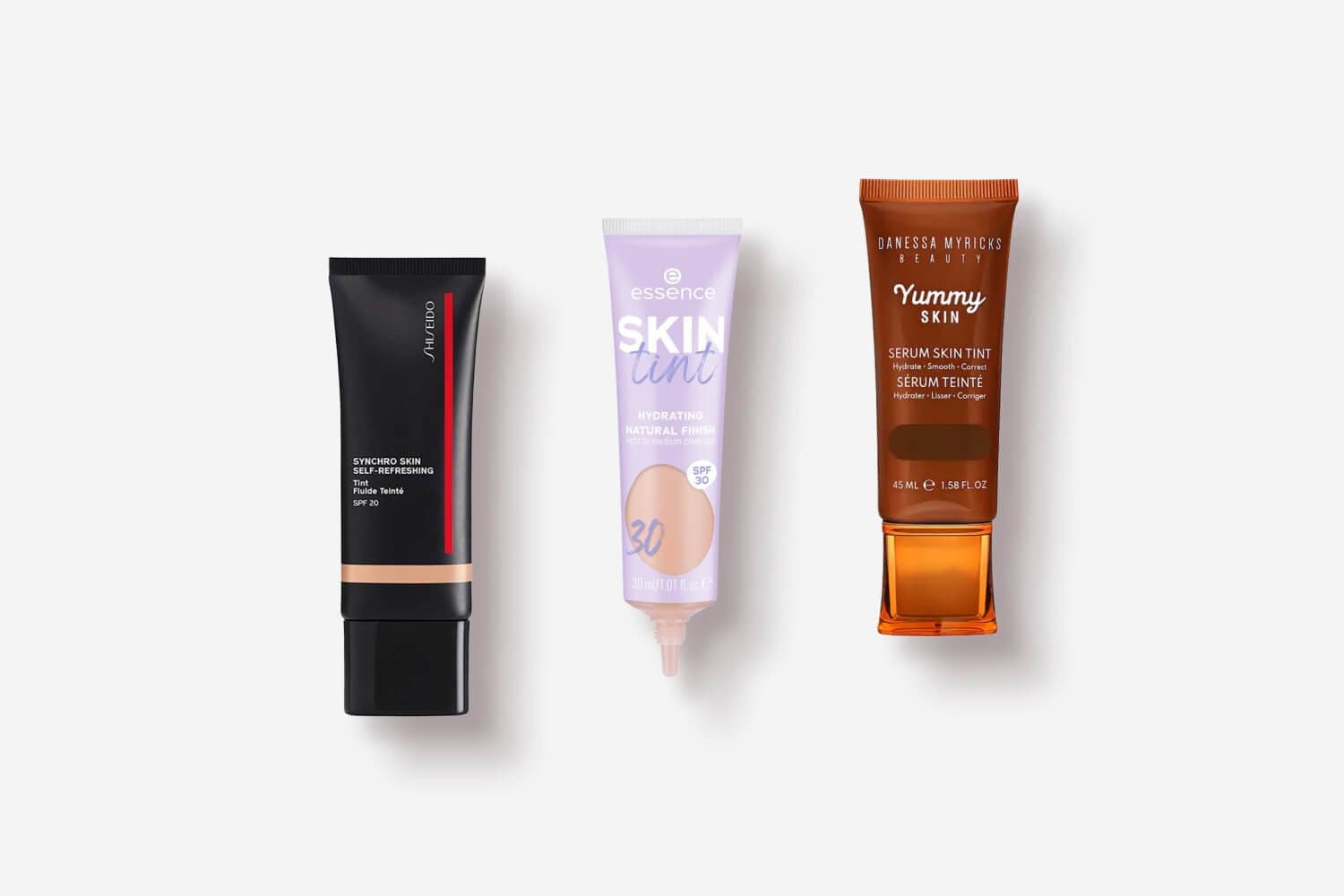 Shiseido Synchro Skin Self-Refreshing Tint SPF 20, essence Skin Tint SPF 30 and Danessa Myricks Yummy Skin Serum Skin Tint tubes in a row.