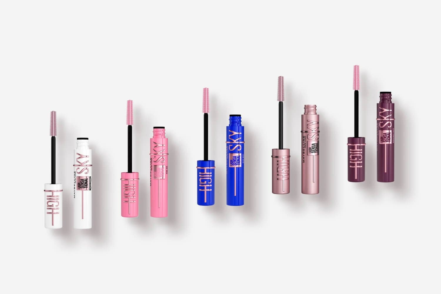 Five open Maybelline Lash Sensational Sky High mascaras in white, pink, blue, rose and burgundy tubes with pink wands.