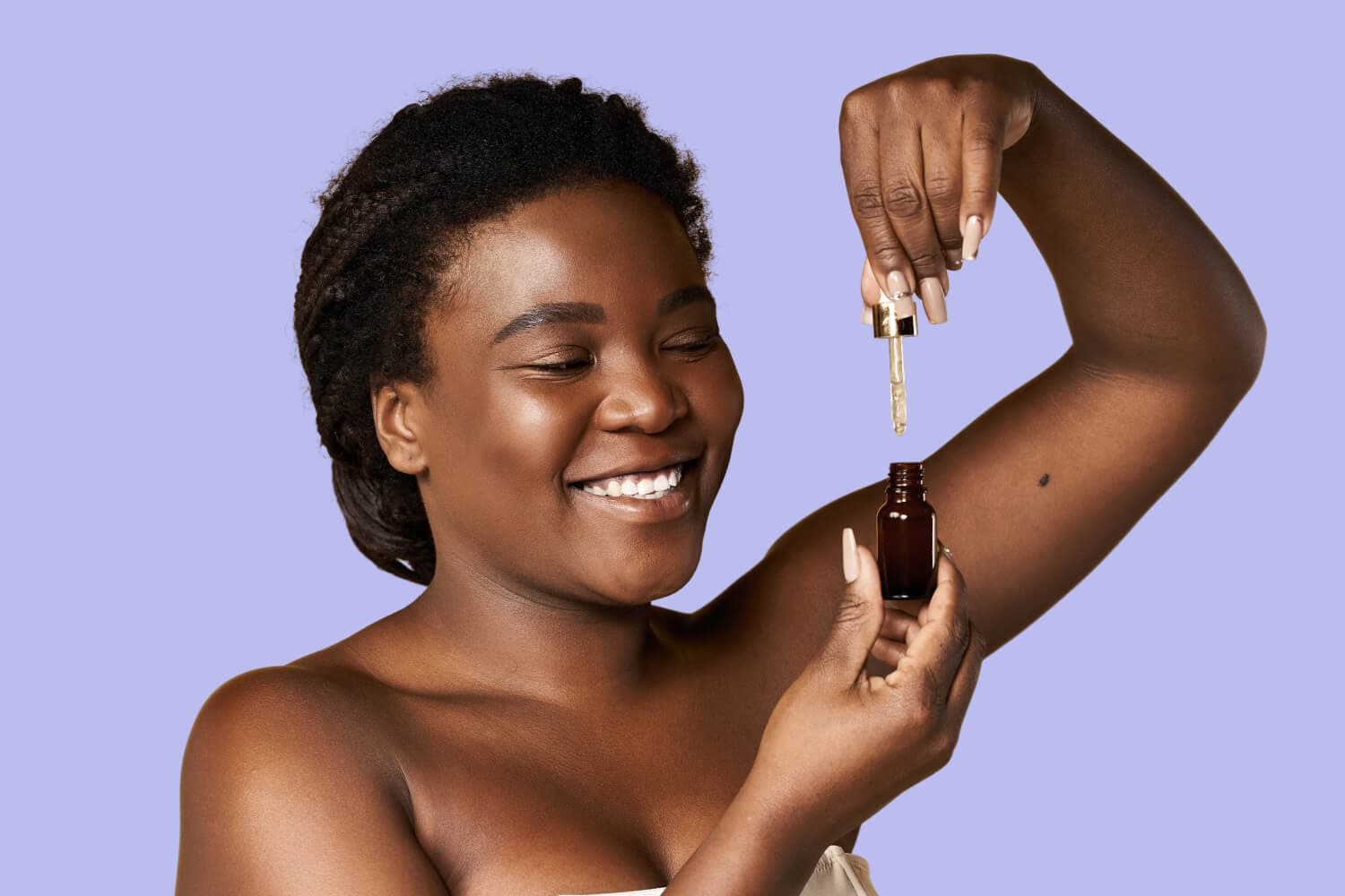 Smiling woman holding an unlabelled amber serum bottle and gold dropper against a lilac background. Smiling woman holding an unlabelled amber serum bottle and gold dropper against a lilac background.